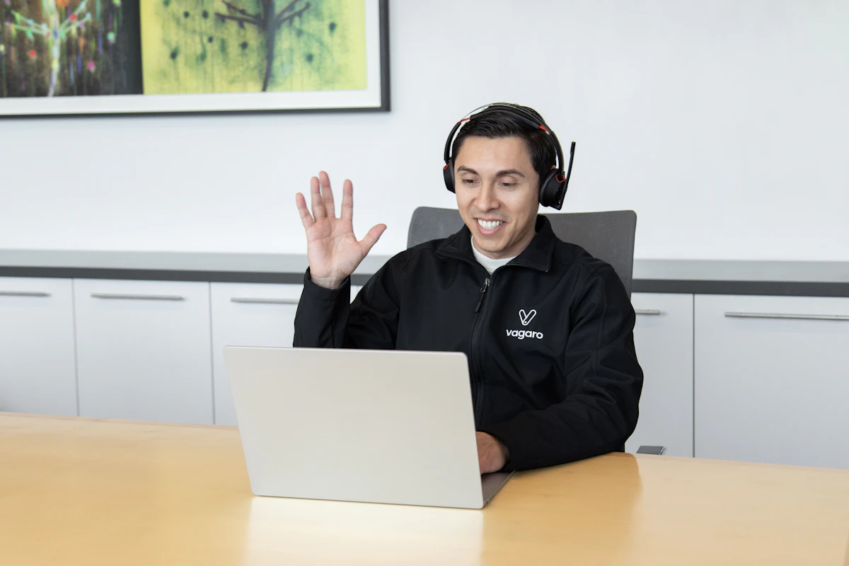 Support engineer with a headset helping a client from a laptop