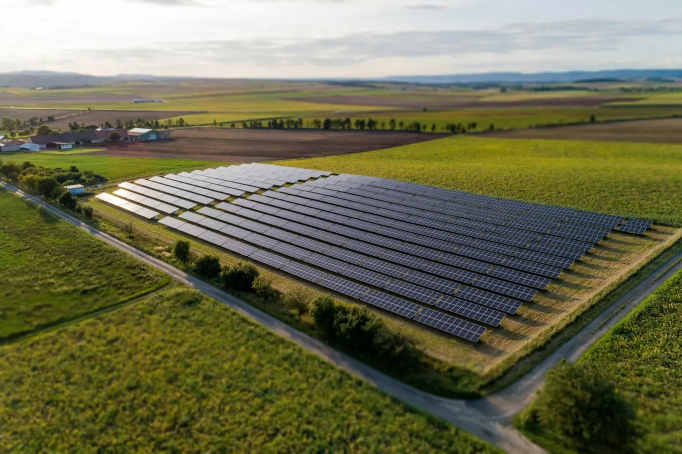 Rows of solar panels on a green field at a ground-mounted solar plant