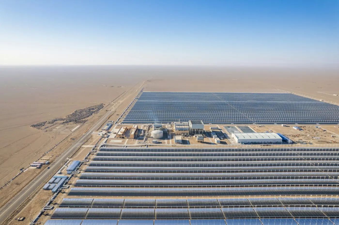 Aerial view of a large solar power plant with rows of panels