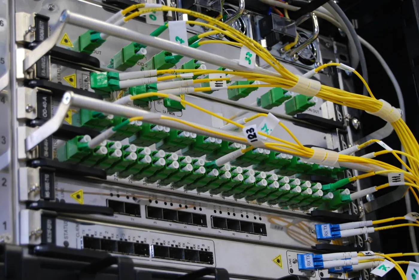 Fibre-optic cables connected to a network switch in a server rack